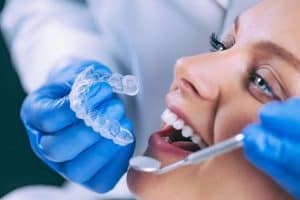 Orthodontist putting Invisalign on patient's teeth