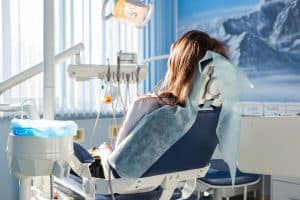 patient sitting on dental chair waiting anxiously for her dentist
